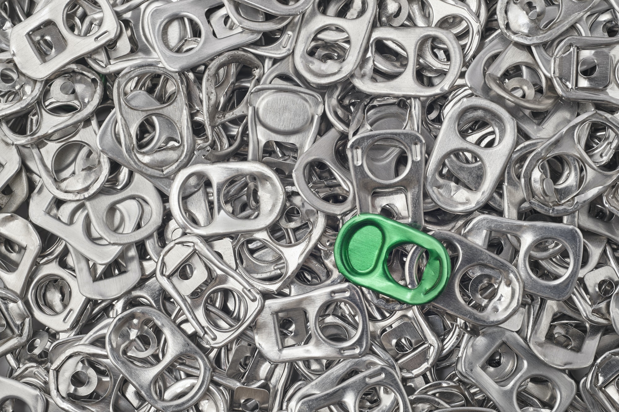 Recycling aluminum background with pull-tab pieces. Metallic waste. Horizontal